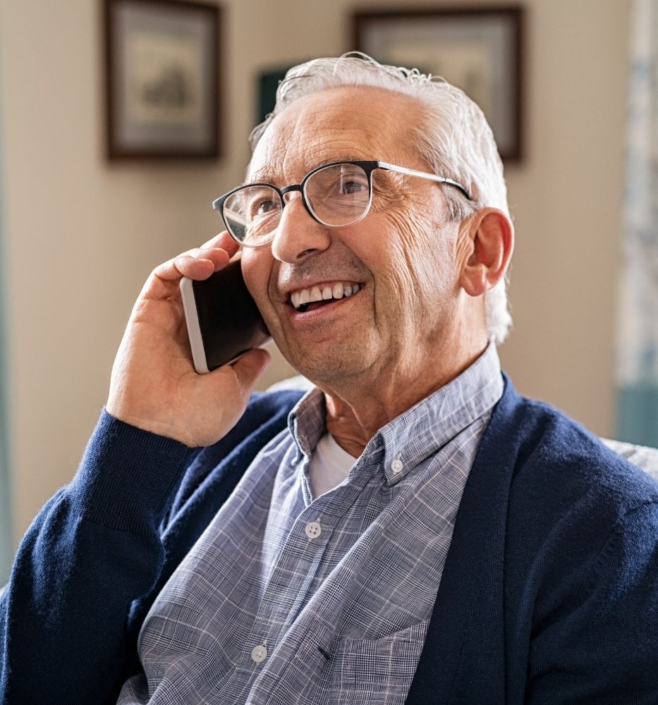 Elderly man on mobile telephone smiling